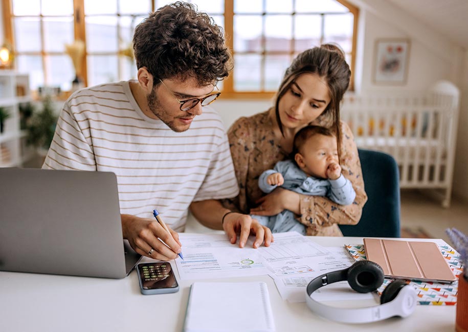 A young couple with a baby going over financials